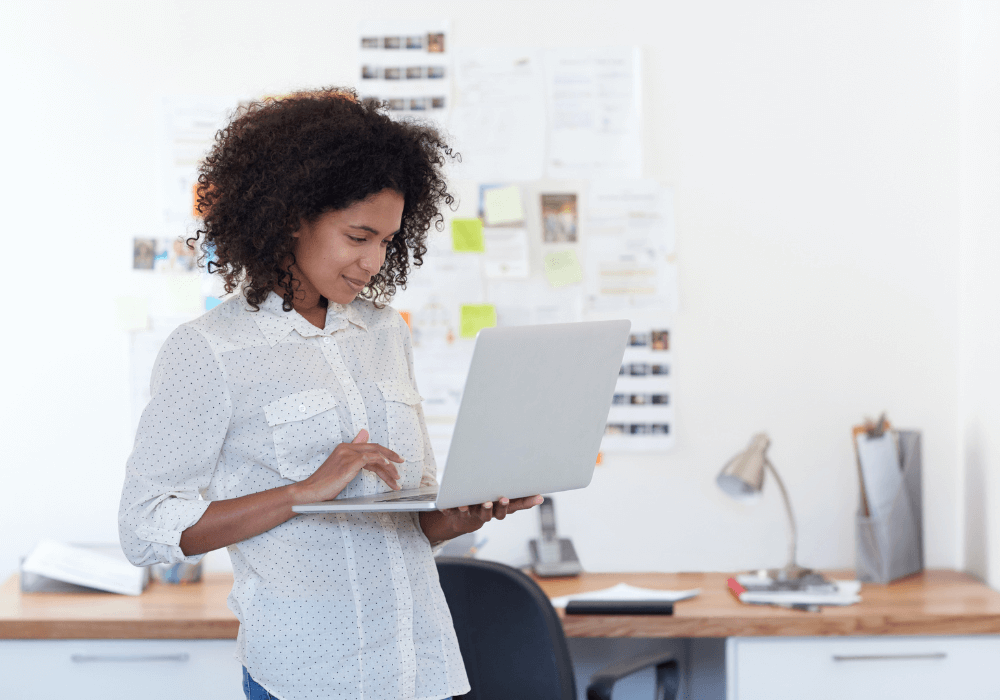woman looking standing looking at her website on a laptop